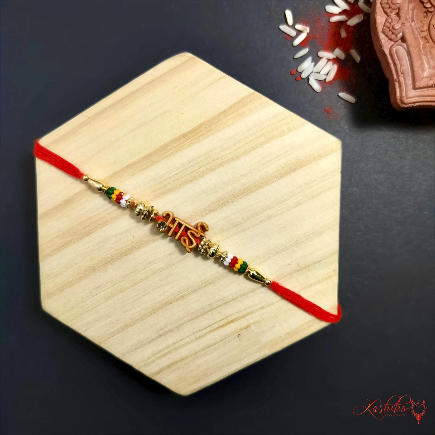 Decorative bracelet with beads and red thread on a wooden coaster with a dark background