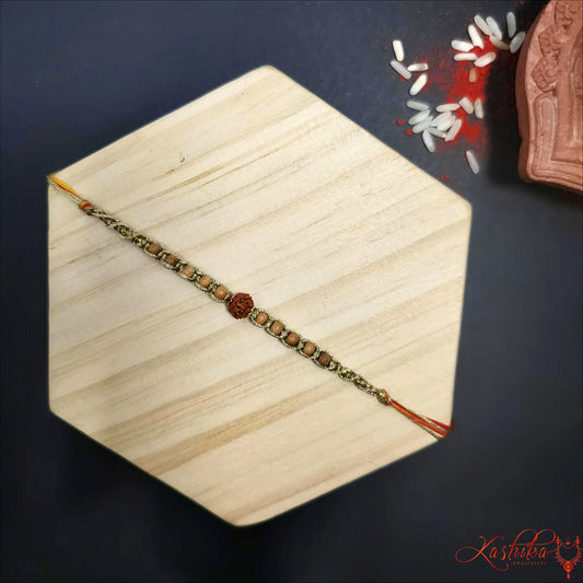 A single rakhi made with brown and beige beads, featuring a central dark brown Rudraksha bead , laid on the light textured surface