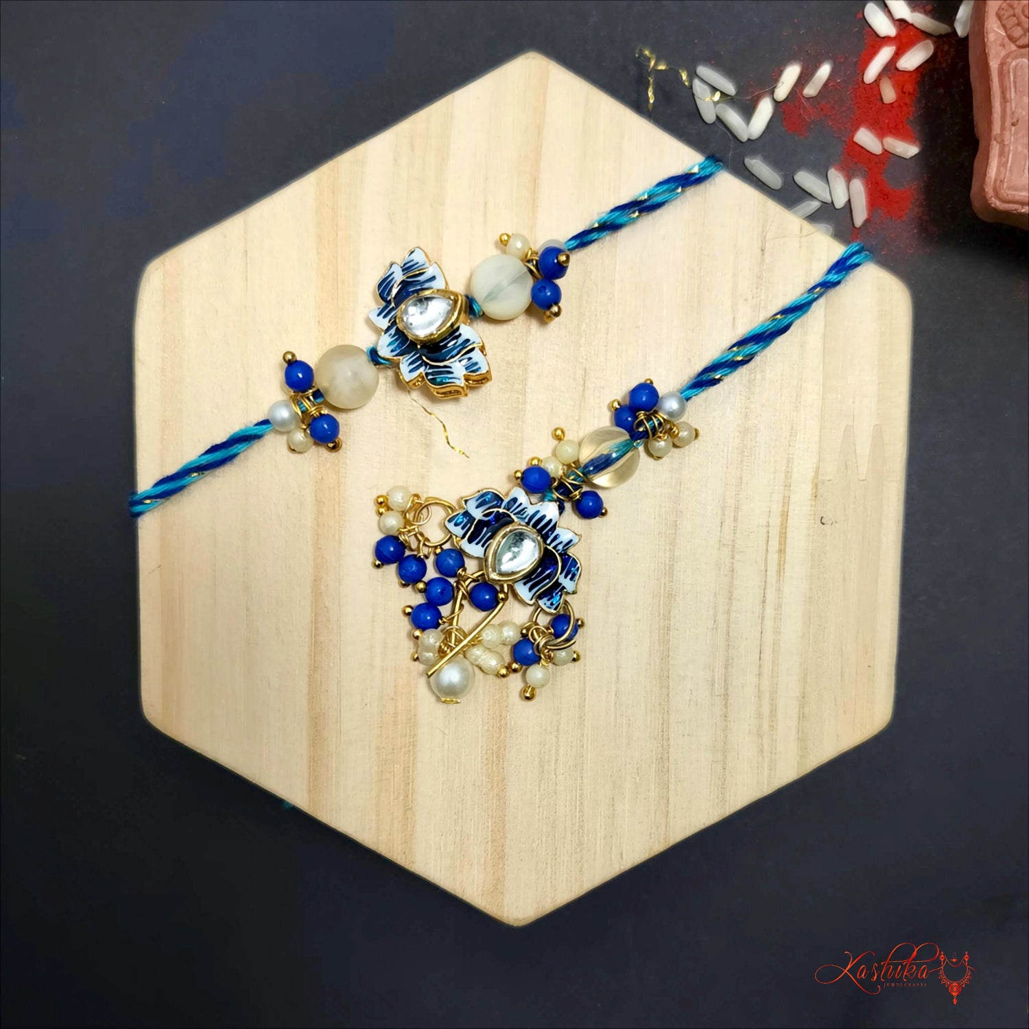 Blue enamel kundan couple rakhi set featuring a blue rakhi for brother and a matching blue enamel floral lumba rakhi for sister-in-law 