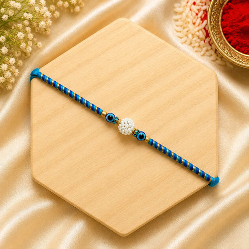 Blue Evil Eye Pearl Bhai Rakhi handcrafted with premium blue thread and elegant pearl centre bead, designer Raksha Bandhan rakhi for brother by Kashika JewelCrafts.