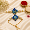 Royal Blue Hindi Bhai & Dabang Bhabhi Resin Bhai Bhabhi Rakhi Set featuring gold foil resin charms, pearl embellishments, adjustable designer Lumba, and matching Bhai Rakhi by Kashika JewelCrafts.