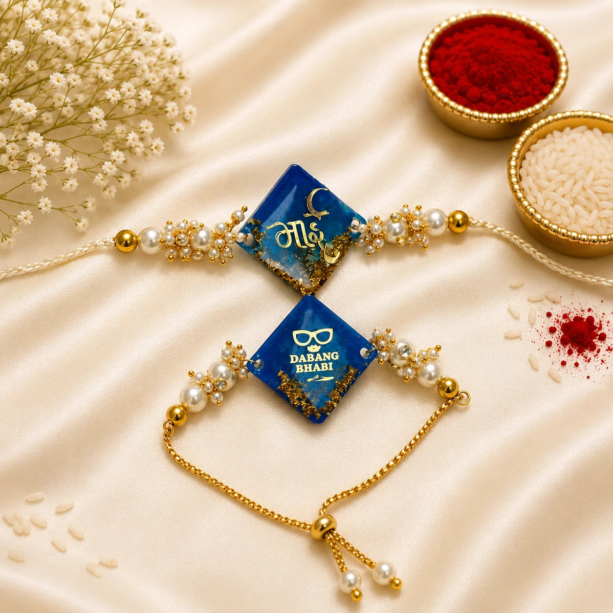 Royal Blue Hindi Bhai & Dabang Bhabhi Resin Bhai Bhabhi Rakhi Set featuring gold foil resin charms, pearl embellishments, adjustable designer Lumba, and matching Bhai Rakhi by Kashika JewelCrafts.