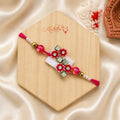 Pink Floral Mirror Bhai Rakhi handcrafted with crystal stones, mirror work, pink beads, and pearl accents by Kashika JewelCrafts.
