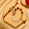 Handmade Red Kundan Pearl Bhai Bhabhi Rakhi Set featuring a round kundan centerpiece with pearl border, red beads, gold accents, and a matching pearl tassel Lumba by Kashika JewelCrafts.