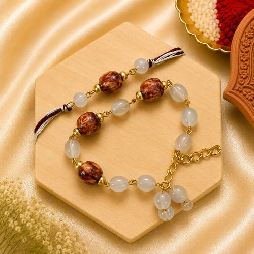 Handmade Brown Pearl Bhai Bhabhi Rakhi Set featuring wooden-textured beads, pearl accents, neutral beads, and a matching designer Lumba Rakhi by Kashika JewelCrafts.