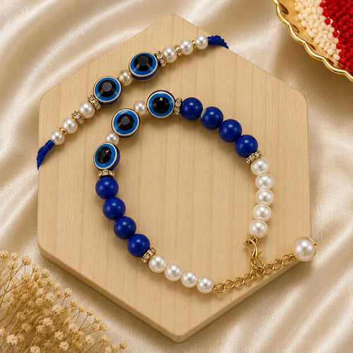 Handmade Blue Evil Eye Bhai Bhabhi Rakhi Set featuring blue evil eye charms, royal blue beads, pearl accents, and a matching designer Lumba bracelet by Kashika JewelCrafts.