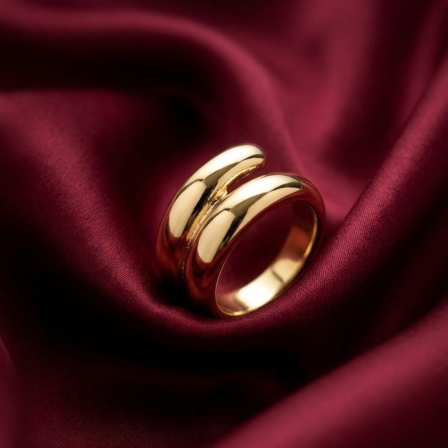 Gold ring on a burgundy fabric background