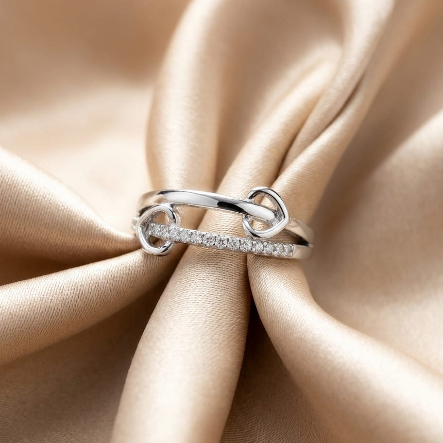 Silver ring with small diamonds on a beige fabric background
