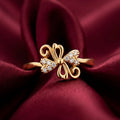 Gold butterfly ring with diamonds on a burgundy fabric background