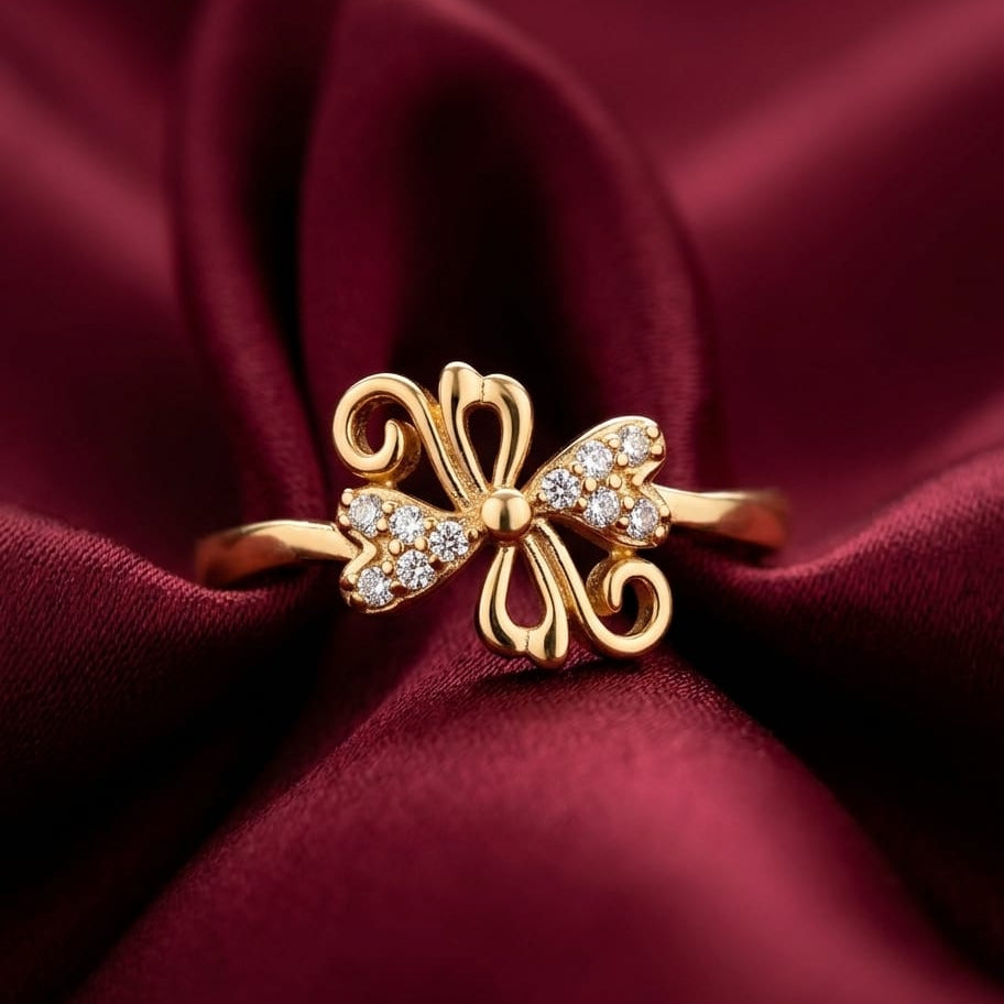Gold butterfly ring with diamonds on a burgundy fabric background