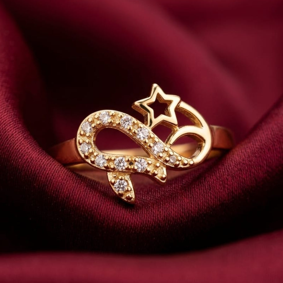 Gold ring with star and snake design on a red fabric background