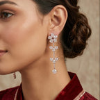 Woman wearing a pair of elegant earrings with a neutral background