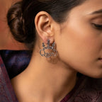 Woman wearing a decorative earring with a blurred background