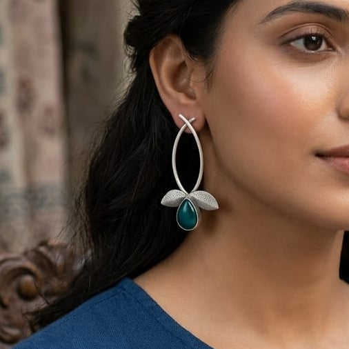 Woman wearing blue earrings with a blurred background