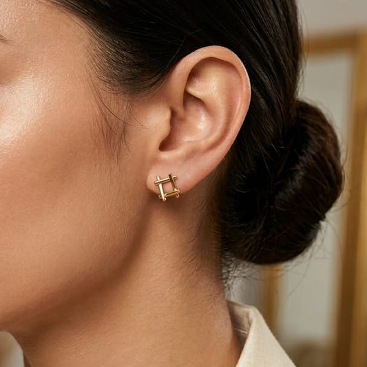 Close-up of a woman wearing gold earrings with a blurred background
