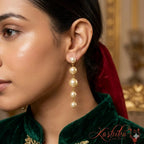 Close-up of a woman wearing pearl earrings with a blurred background