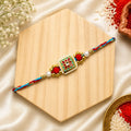 Multicolor Floral Kundan Bhai Rakhi handcrafted with a square floral centerpiece, pearl accents, gold beads, and braided thread by Kashika JewelCrafts.
